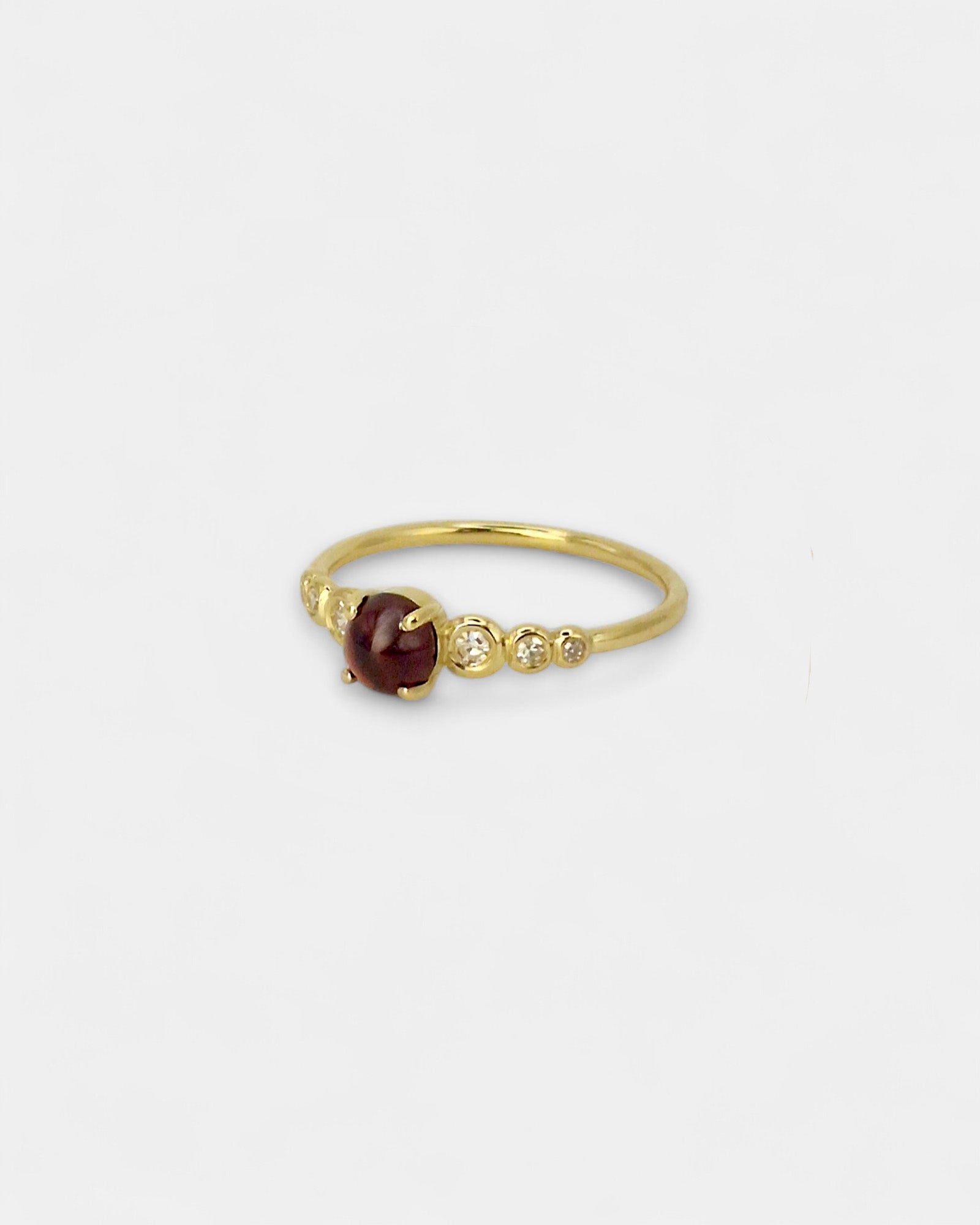 Anello in oro giallo con granato cabochon e diamanti bianchi in scala