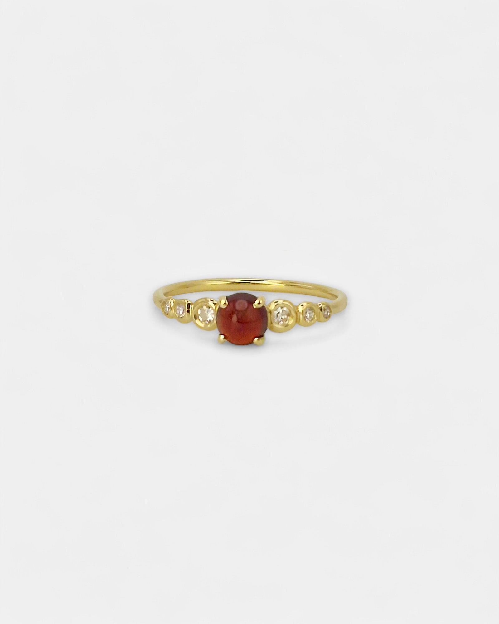Anello in oro giallo con granato cabochon e diamanti bianchi in scala