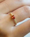 Yellow gold ring with orange sapphire and round elements with white diamonds