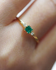 Anello in oro giallo con smeraldo carrè e due diamanti bianchi