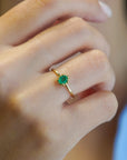 Yellow gold ring with oval emerald and decorated bezel