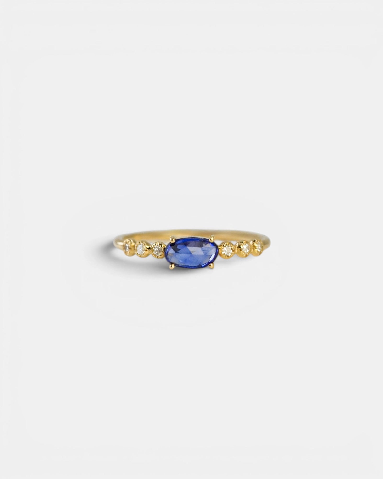 Yellow gold ring with blue sapphire and round elements with white diamonds