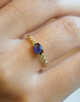 Yellow gold ring with blue sapphire and round elements with white diamonds