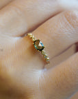 Yellow gold ring with green sapphire and round elements with white diamonds