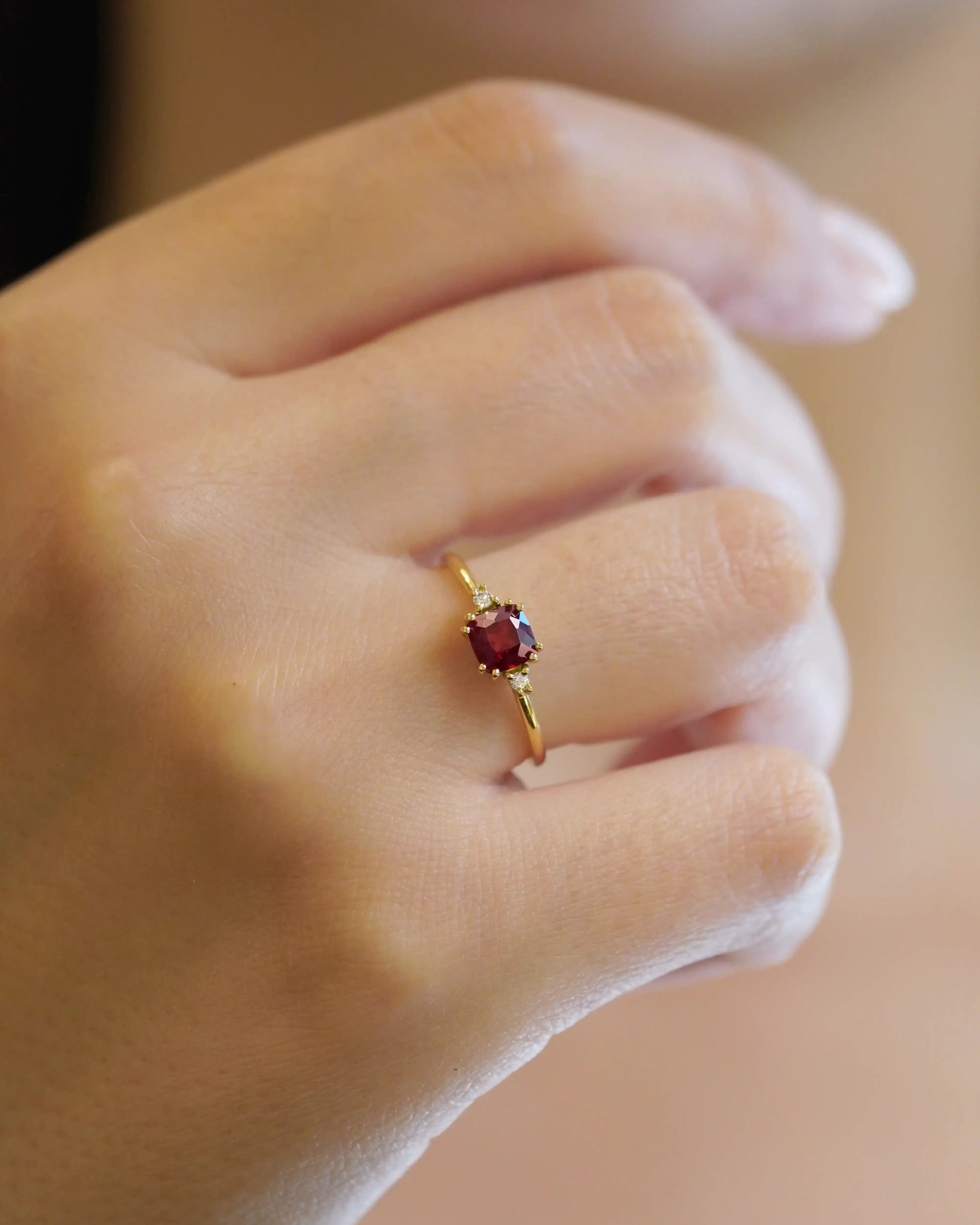 Anello in oro giallo con granato quadrato e due diamanti bianchi