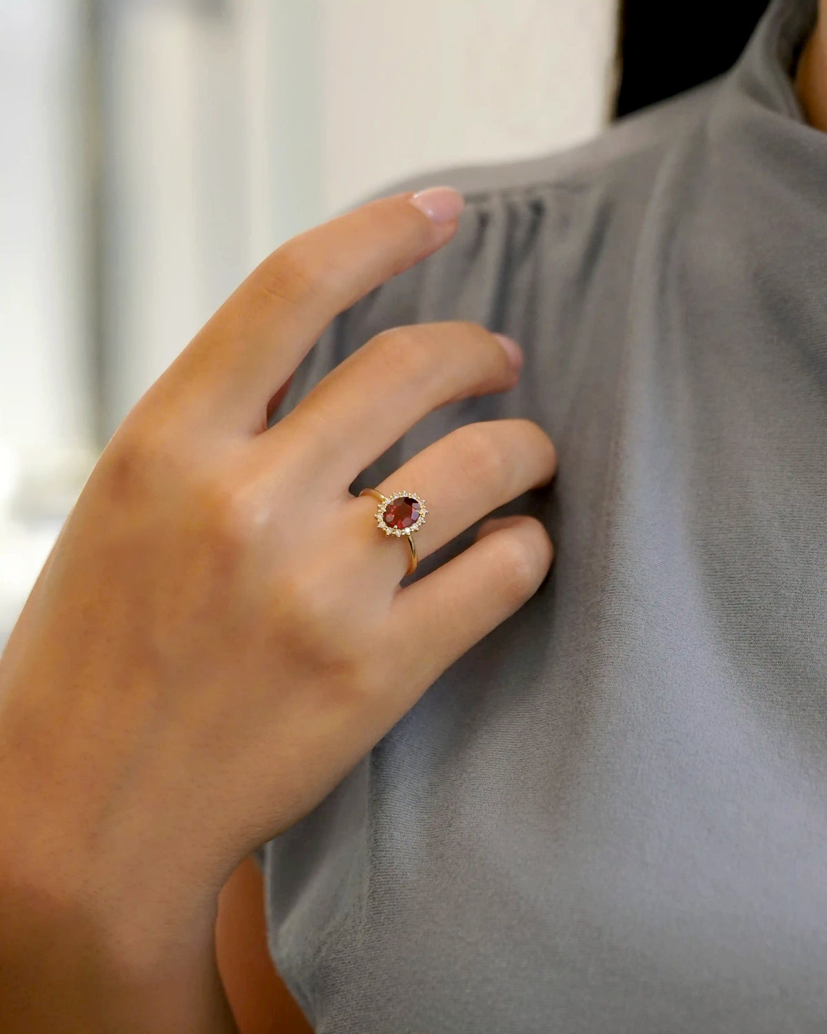 Anello in oro giallo con granato ovale e contorno di diamanti
