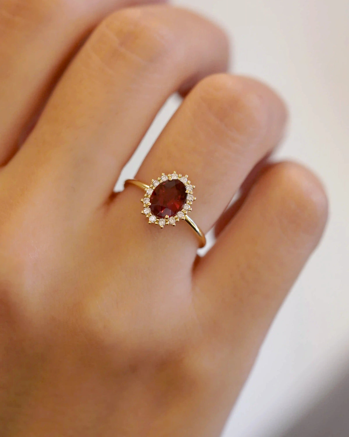 Anello in oro giallo con granato ovale e contorno di diamanti