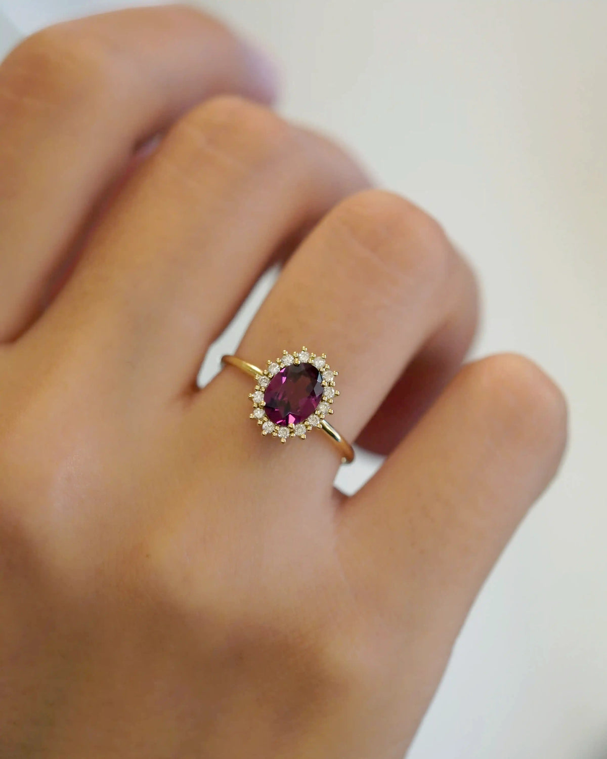 Yellow gold ring with oval rhodolite and white diamond contour