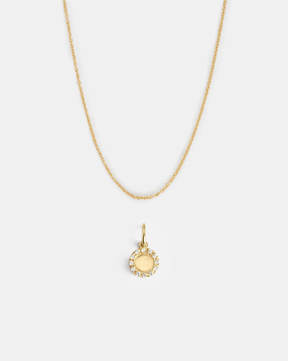 Round gold pendant with halo of white diamonds