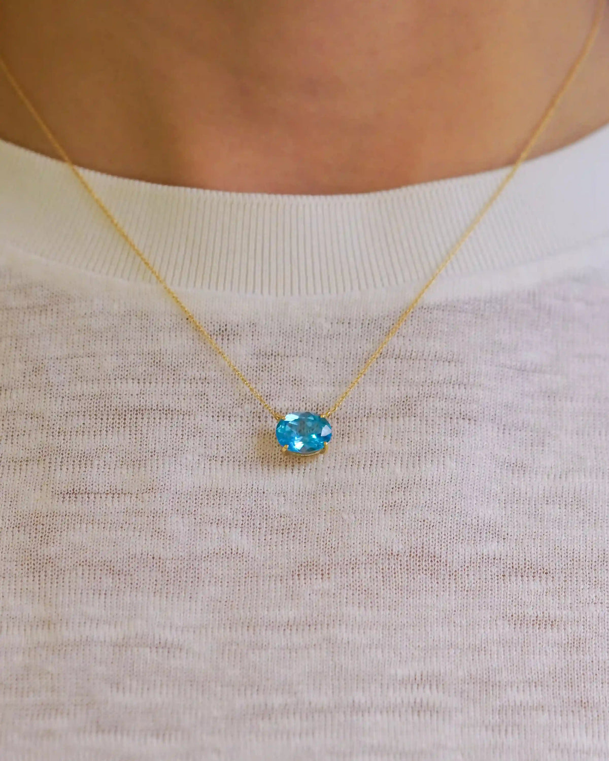 Yellow gold necklace with oval light blue topaz