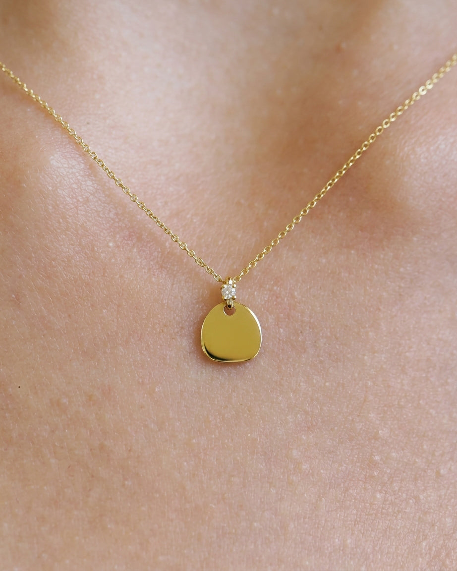 Yellow gold necklace with pebble pendant and diamond detail