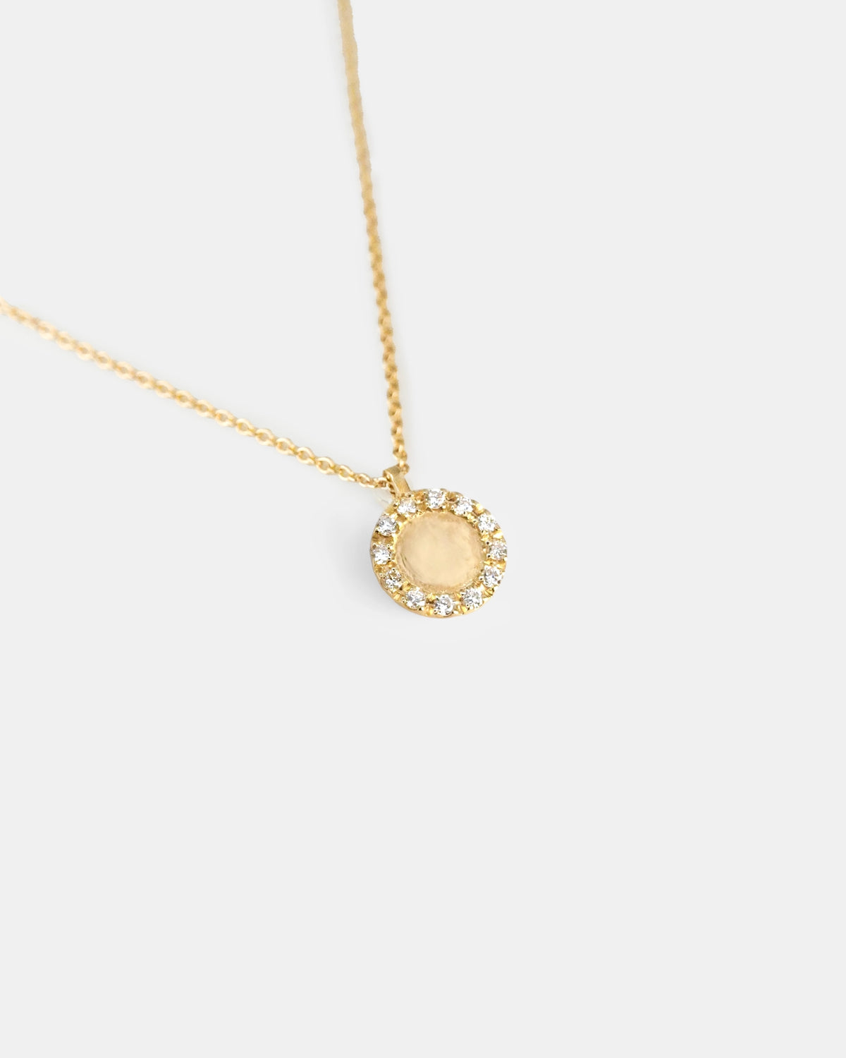 Yellow gold necklace with round pendant with white diamond contour